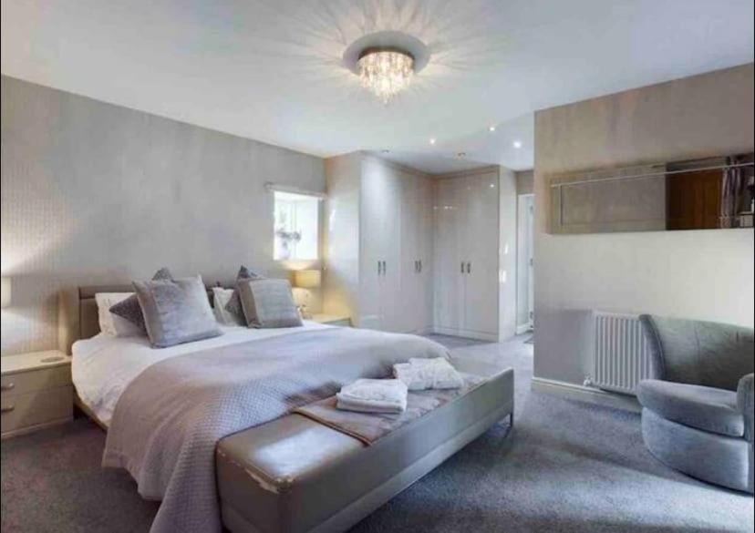 a large bedroom with a large bed and a chair at The Oaks A private room in our home With its own entrance with internal doors locked More suited to quieter guests wanting a peaceful stay in Consett