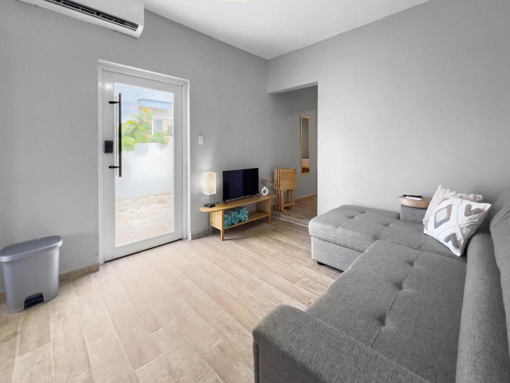 a living room with a couch and a television at Casa Cueva Beach House for 14 PPL in Arecibo in Arecibo