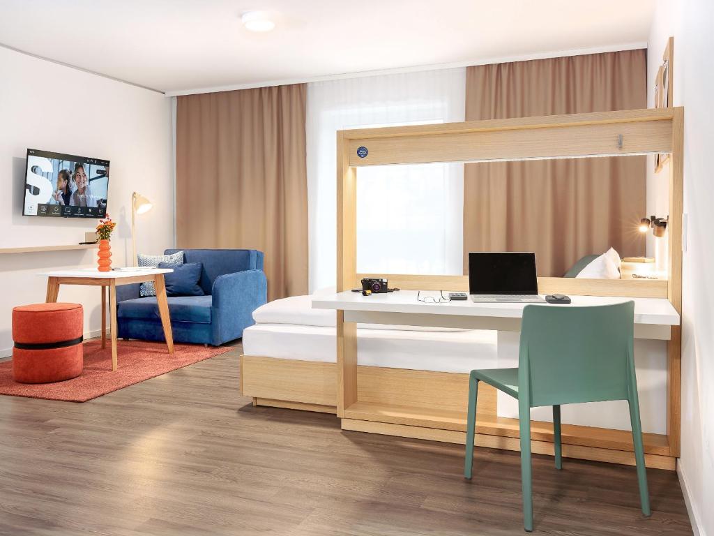 a bedroom with a bed and a desk with a laptop at smartments Hamburg Hamm in Hamburg