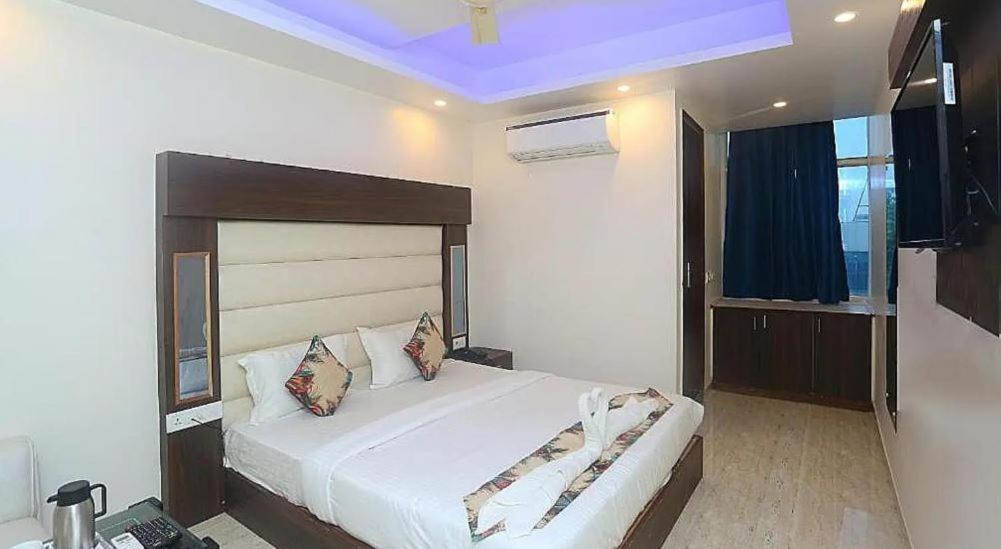 Un dormitorio con una gran cama blanca en una habitación. en Raj Niwas Delhi, en Dehradun