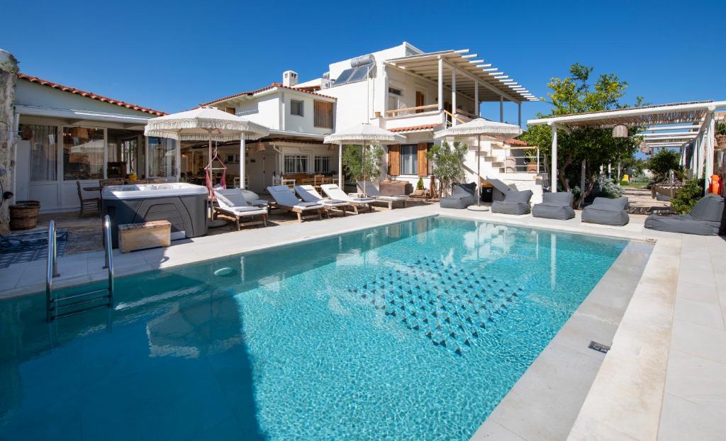 a swimming pool in front of a house at Villa Arancia Private Pool, 2 Jacuzzis & BBQ Area in Pigi