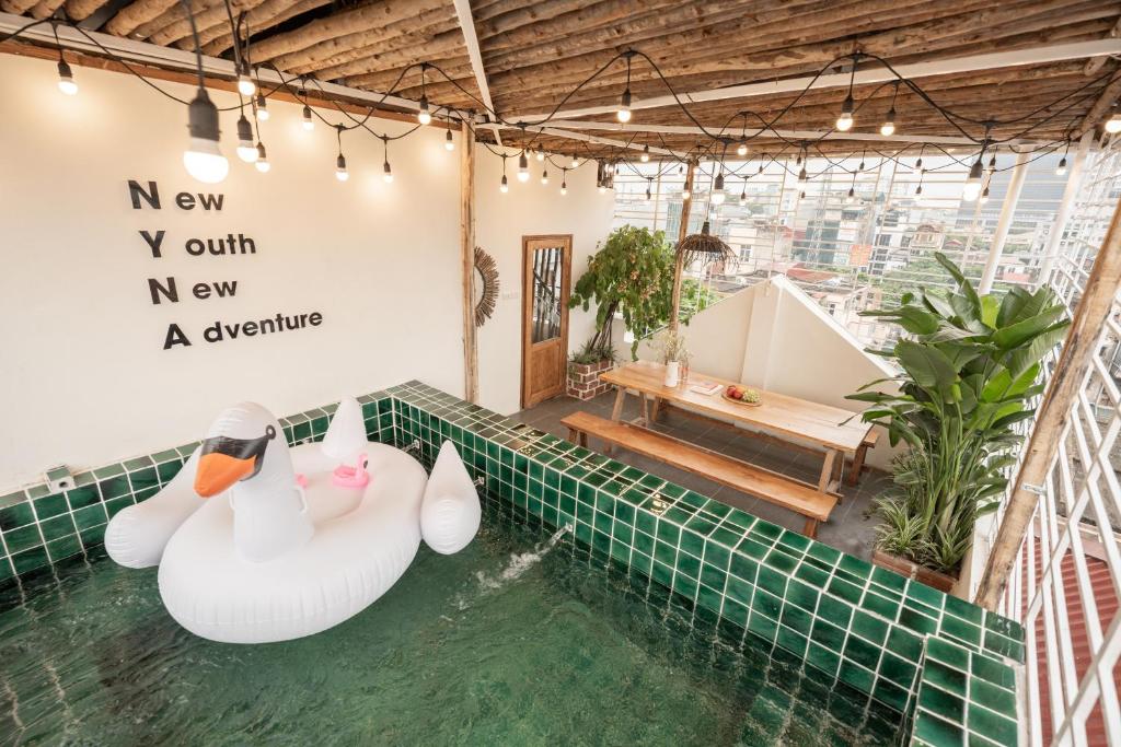 dos cisnes de caucho en el agua en una piscina en Bright Wooden House near Old Quarter, en Hanói