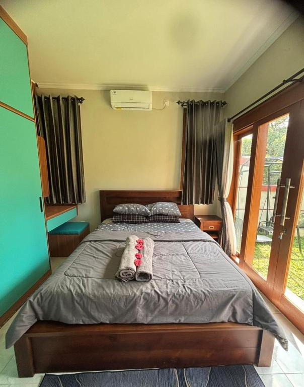 a bedroom with a bed with a pillow on it at Bumbab House by Pigeon in Nusa Dua