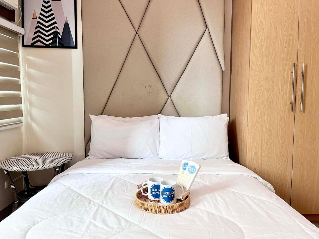 een bed met twee kopjes en een dienblad erop bij Relax Stay at One Madison Tower in Cari Mayor