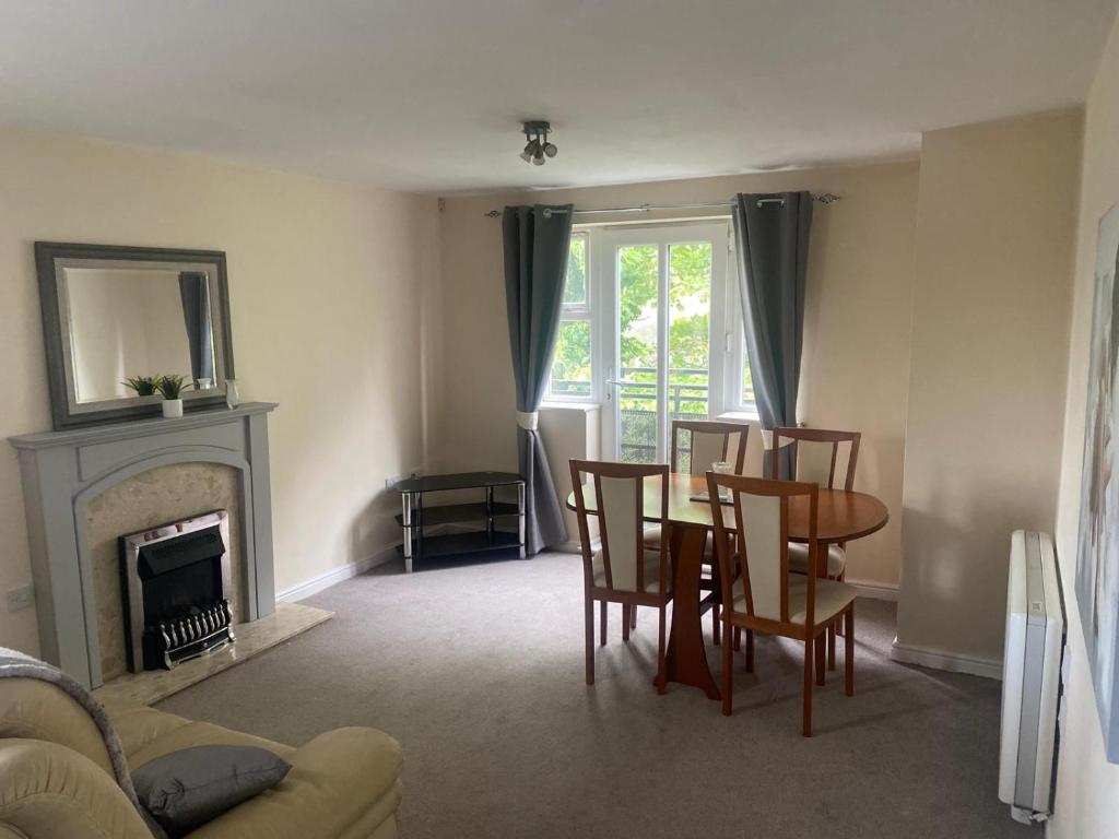 a living room with a table and chairs and a fireplace at Friars terrace in Stafford
