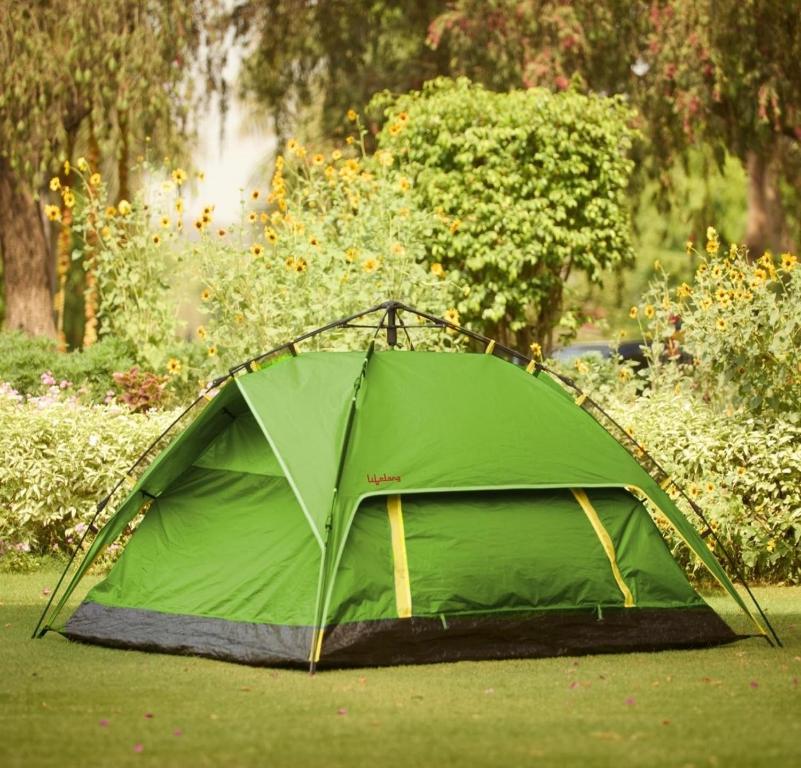 Trail4WD Adventure Camp Malshej Hills في مالشيج جات: خيمة خضراء تجلس على العشب في الحديقة