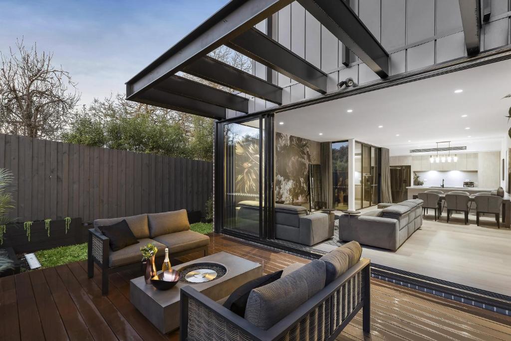 a patio with a couch and a table at Ivanhoe Five Luxury Holiday Home 4 Bed Sleep 6 in Melbourne