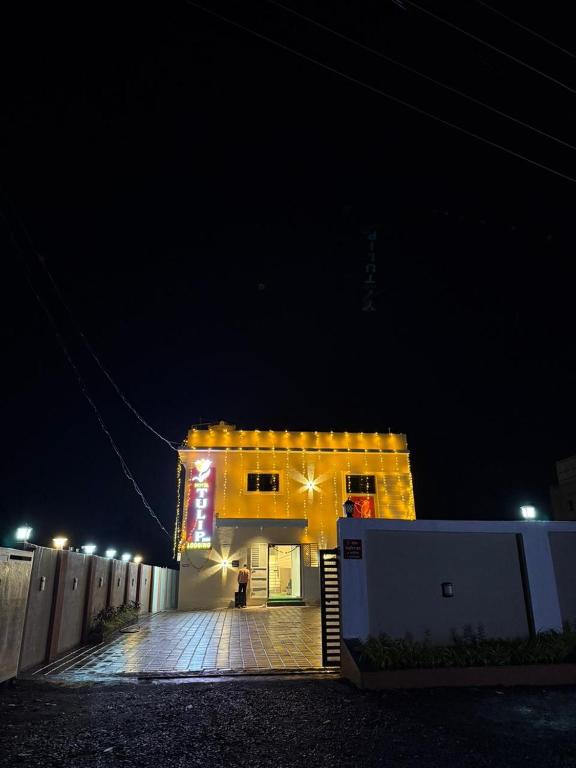a building at night with a person standing outside at Hotel Tulip Inn & Lodging in Viravdi
