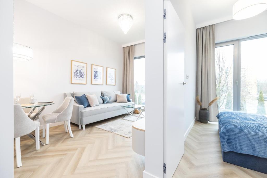 ein weißes Wohnzimmer mit einer Couch und einem Tisch in der Unterkunft Apartament Heaven Hampton in Olsztyn