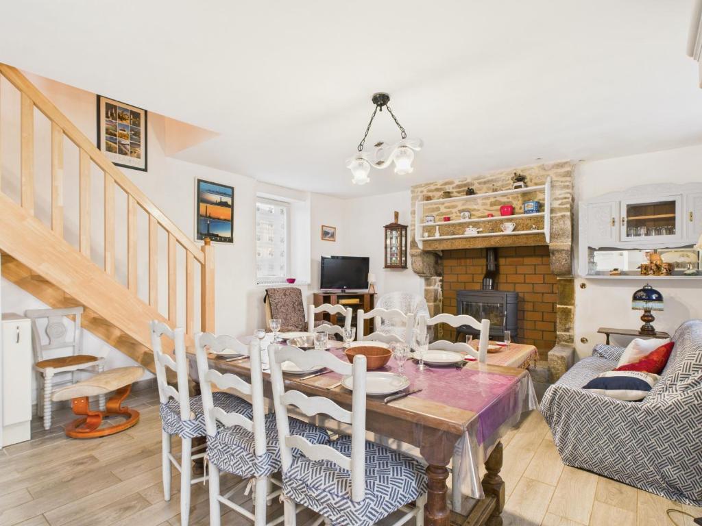 a dining room with a table and a fireplace at Maison pour 7 avec jardin - Quartier paisible in Plouguerneau