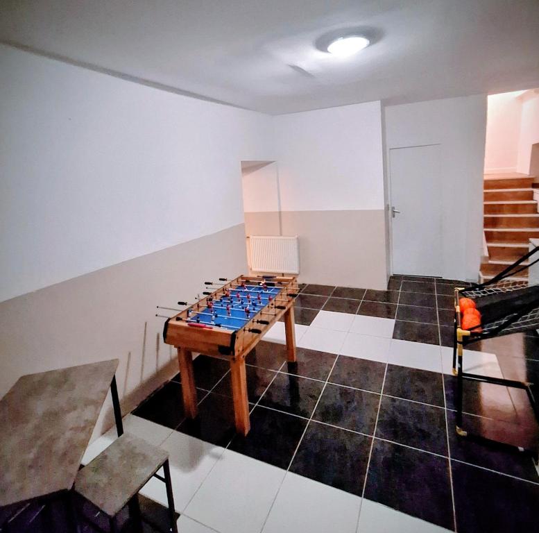 a room with a game table in the middle of it at La maison du château in Saint-Victurnien