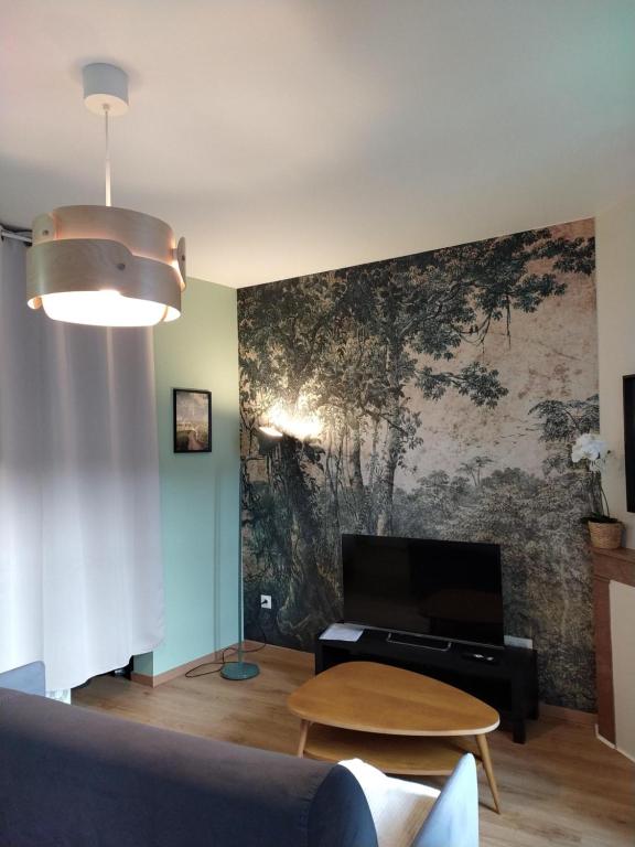 Телевизор и/или развлекательный центр в Appartement calme neuf équipé