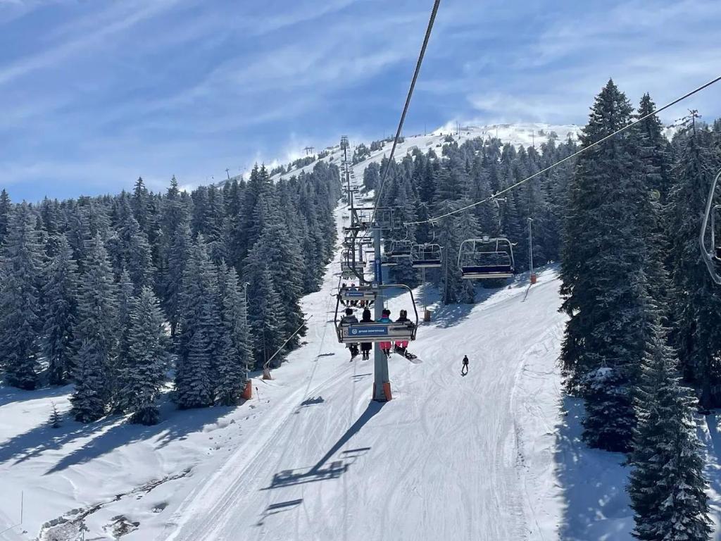 a group of people riding a ski lift in the snow at Studio Apartment ViS in Residence Hill Kopaonik in Kopaonik