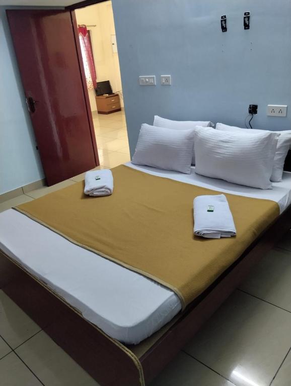 a bed with two towels sitting on top of it at Aruna homes -Lakshana- Thanjavur in Thanjāvūr