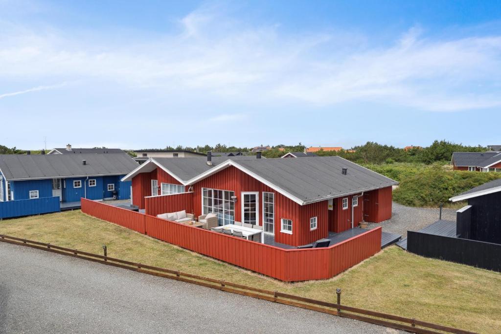Feriehus 3007 في Nørre Lyngvig: صف من البيوت باللونين الأحمر والأزرق