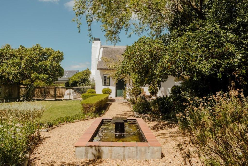 a garden with a fountain in front of a house at Finchlea Cottage in Stanford