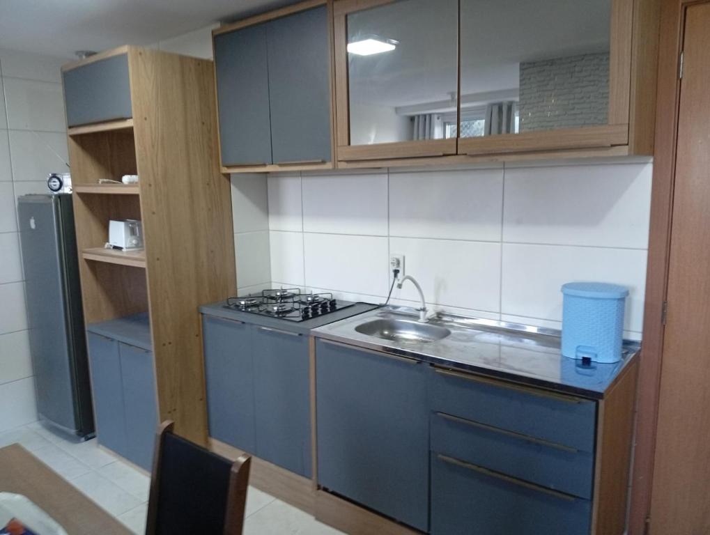 Una pequeña cocina con fregadero y estufa. en Apartamento dentro da ucs universidade, en Caxias do Sul