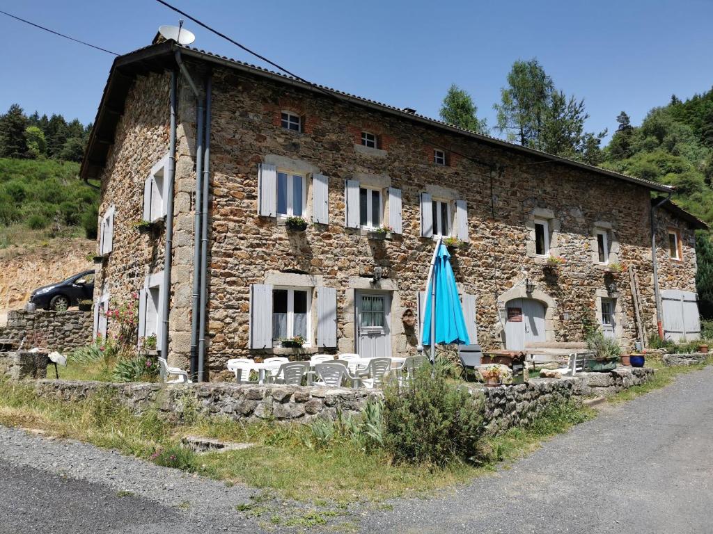a stone building with a blue umbrella in front of it at Chambre Grande Ourse, La maison sous les étoiles in Combelle