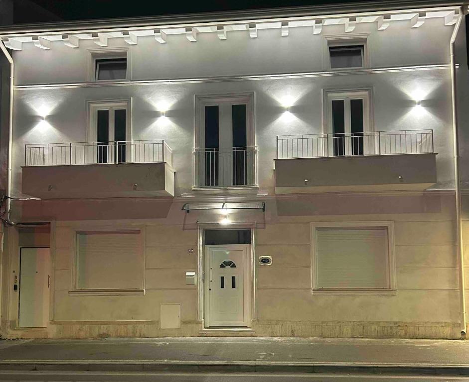 Un edificio blanco con una puerta y un balcón. en Darsena Charming B&B by Villa Valentina Versilia, en Viareggio