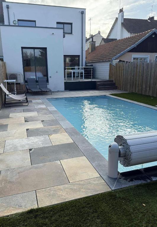 a swimming pool in the backyard of a house at Cozy M&O House in Le Mans