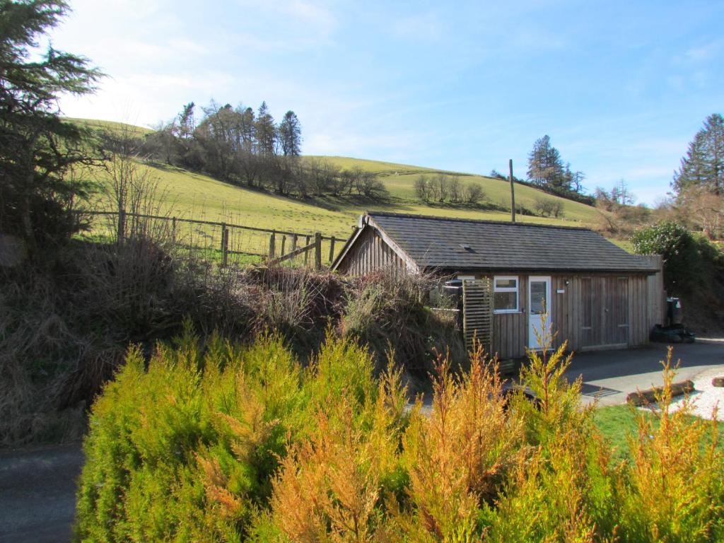 ein kleines Haus mitten auf einem Feld in der Unterkunft Wild Valley Bunkhouse in Llanrhaeadr-ym-Mochnant