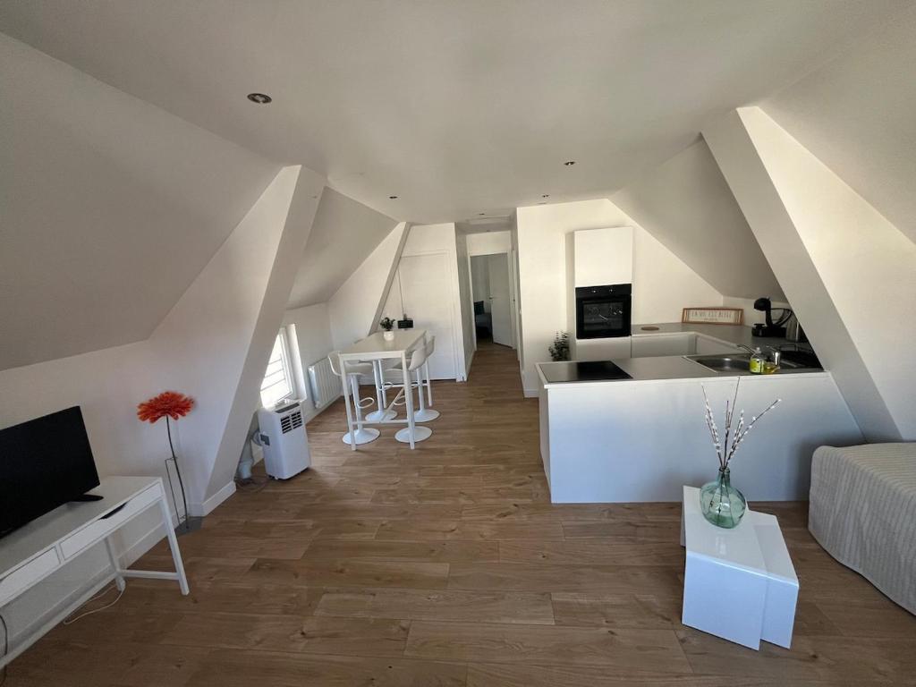a living room with a couch and a kitchen at Magnifique logement indépendant avec sa place de parking in La Celle-sous-Gouzon