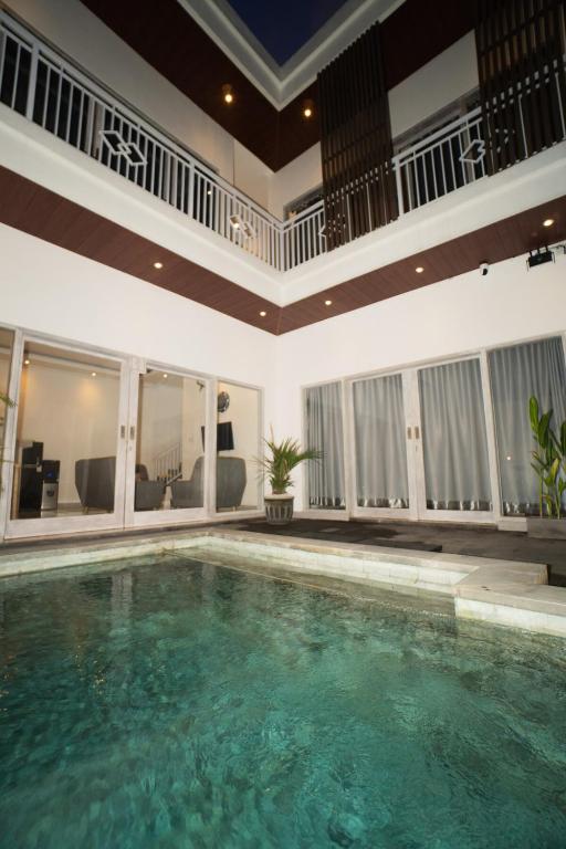 a large swimming pool in a house with a ceiling at Villa cassia in Kerobokan