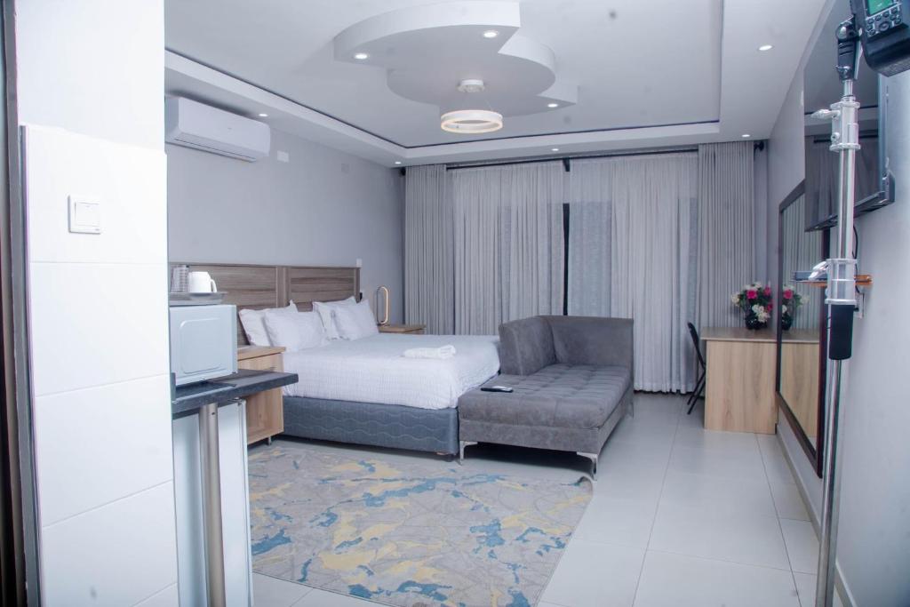 een hotelkamer met een bed en een bank bij Palm Leaf – Hazeldene Kwekwe with pool - 2333 in Kwekwe