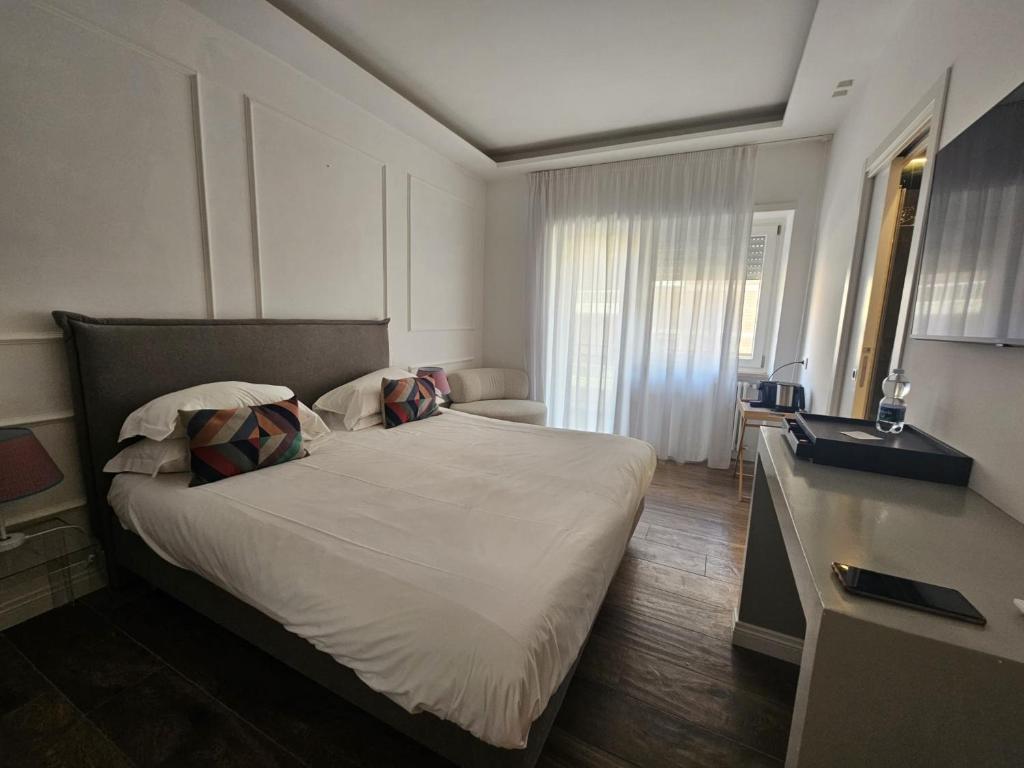 a bedroom with a large white bed with pillows at Be Your Home - Riviera Suites in Civitavecchia