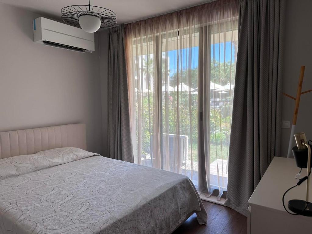 een slaapkamer met een bed en een groot raam bij Апартамент AZUR PREMIUM in Varna