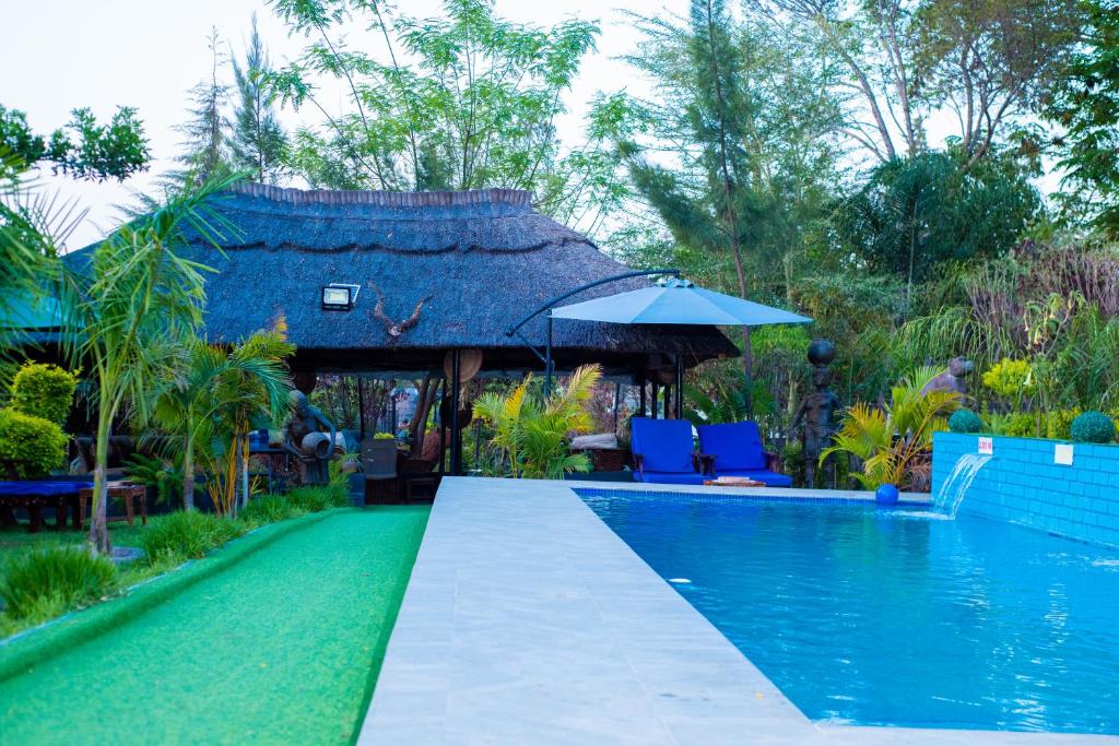 a swimming pool with a gazebo next to a resort at uPhondo Lodge in Bulawayo