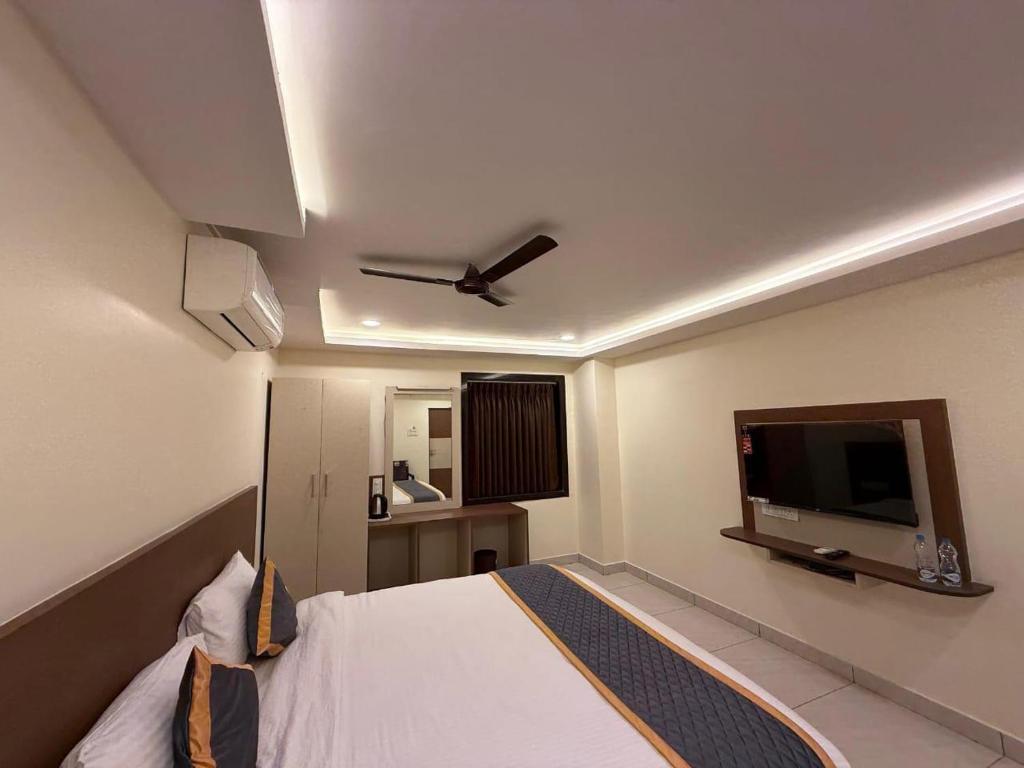 ein Schlafzimmer mit Bett und Flachbildfernseher in der Unterkunft DVR GRAND-AC Rooms in Visakhapatnam