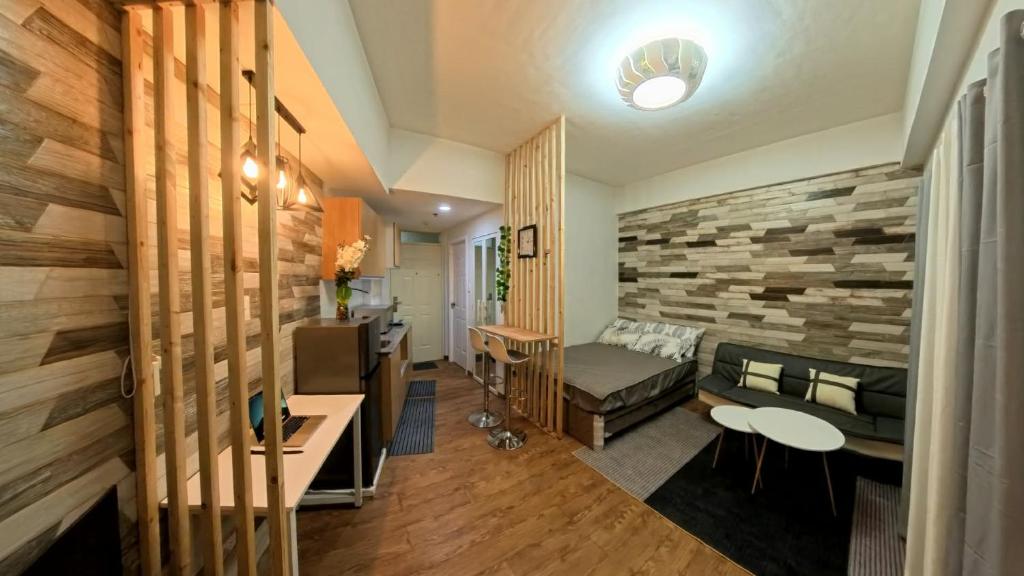 a living room with a couch and a stone wall at Ajira Cozy Condo in Pusok