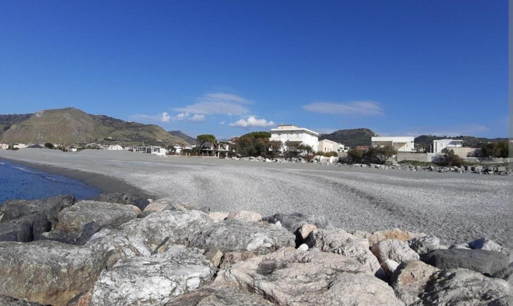 Intero appartamento rinnovato con 3 camere da letto في كامبورا سان جيوفاني: مجموعة من الصخور على شاطئ به بيوت