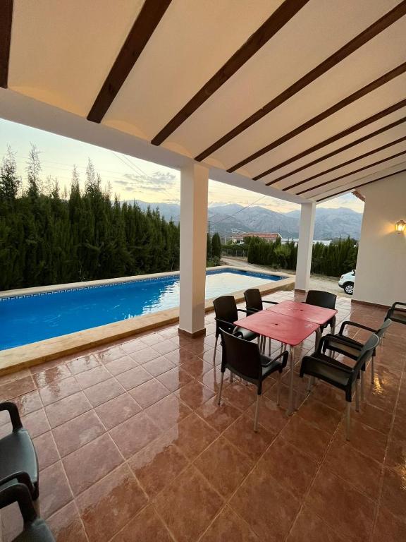a patio with a table and chairs and a pool at Casa de mis sueños Castril in El Batán