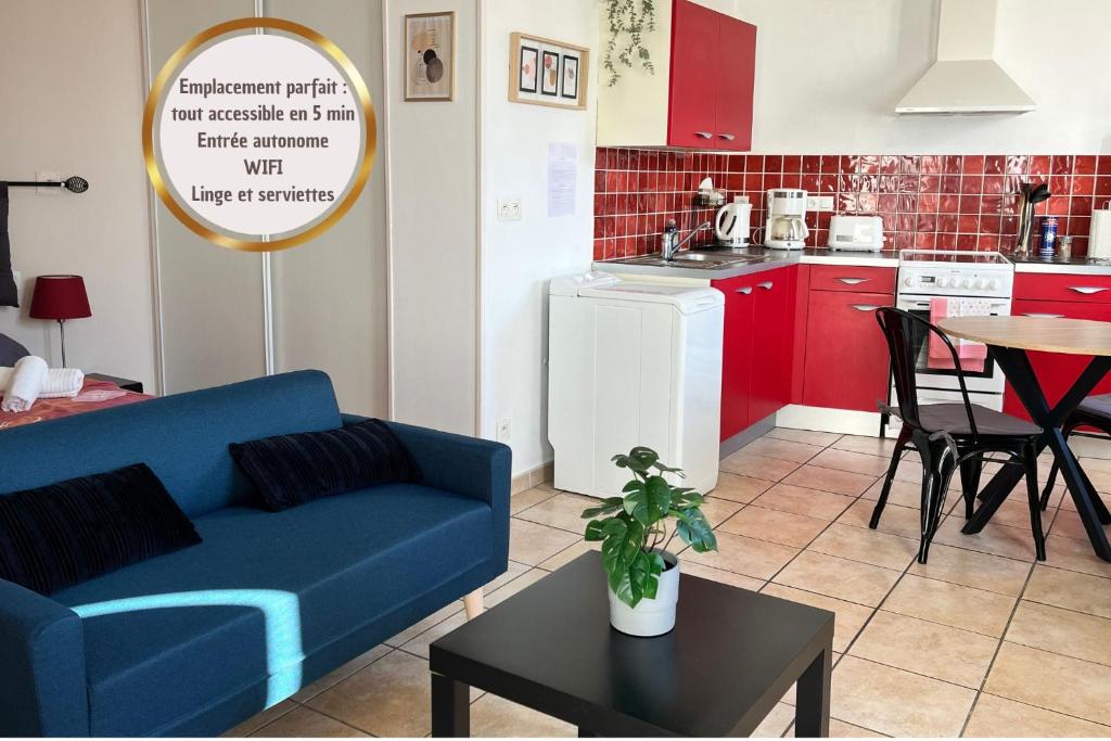 Studio Revy 2 - Centre Ville في نيري ليه بان: غرفة معيشة مع أريكة زرقاء ومطبخ