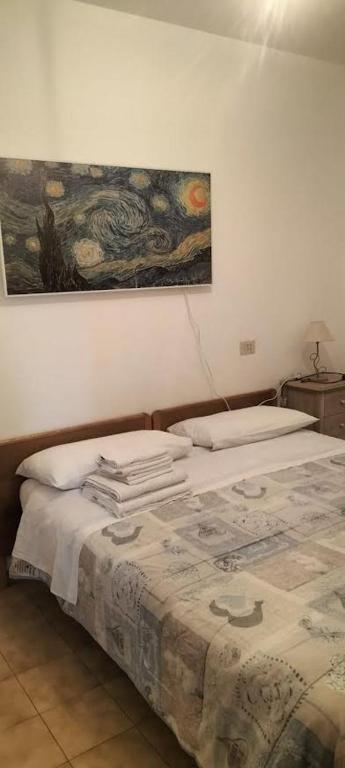 una camera da letto con due letti e un dipinto sul muro di Casa Kalida a Santa Maria a Potenza