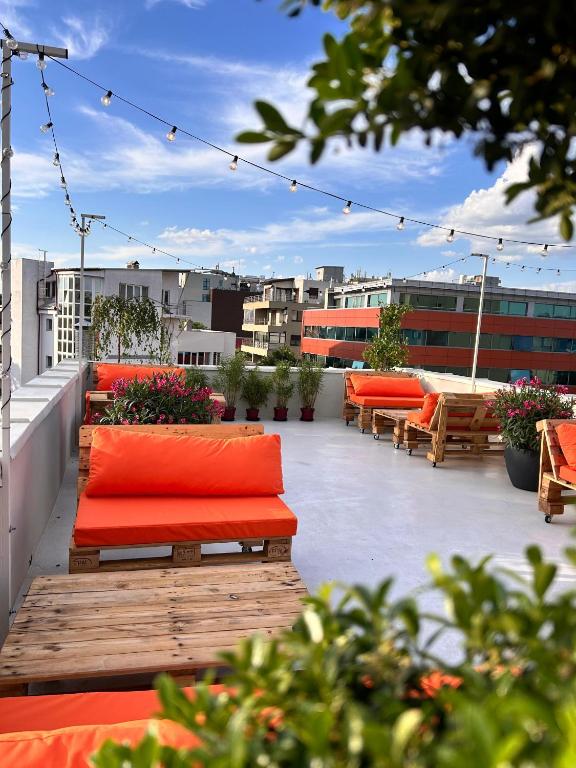 a rooftop patio with benches and flowers on a building at Graffiti Hotel Rooftop - Central Location in Bucharest