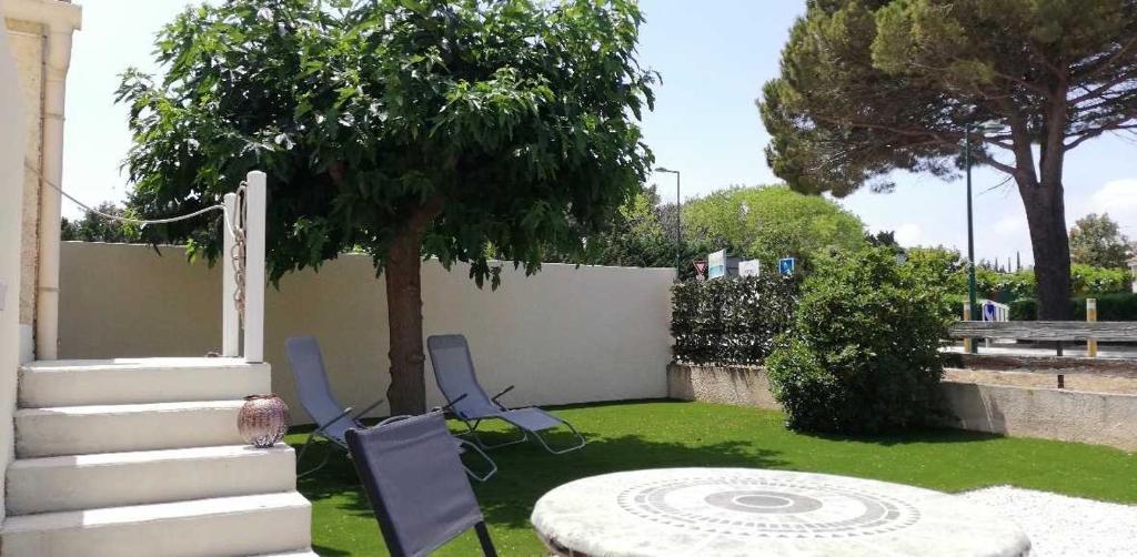 Sea Studio في فيندريه: فناء به كرسيان وطاولة وشجرة