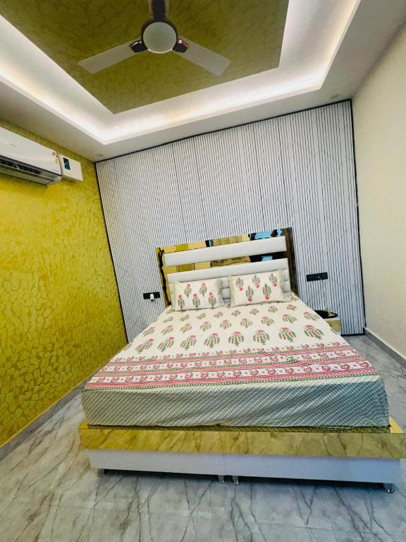 a bedroom with a bed with a ceiling fan at Cloud in Karnāl