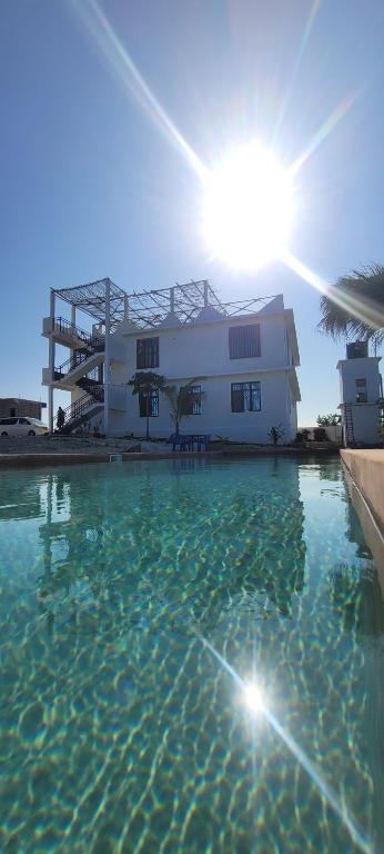 Villa-Katerina-paje Zanzibar apartment في Kiganga: منزل ومسبح امام مبنى