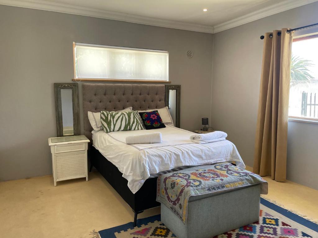 Blouberg kiters في Cape Town: غرفة نوم مع سرير مع اللوح الأمامي ونافذة