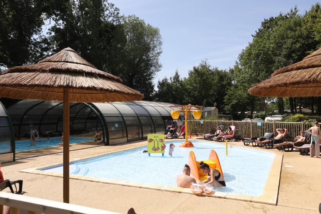 a group of people in a pool at a resort at Camping Le Val de Trie in Béhen