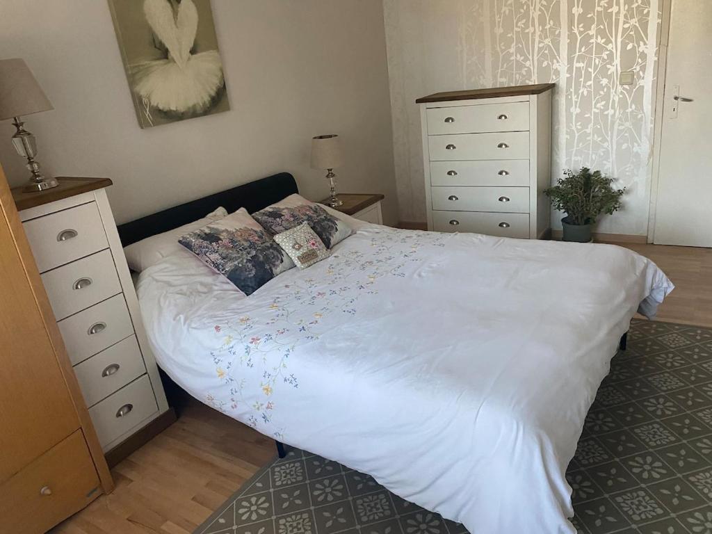 a bedroom with a white bed and a dresser at Angenellyq apartment in Kyustendil