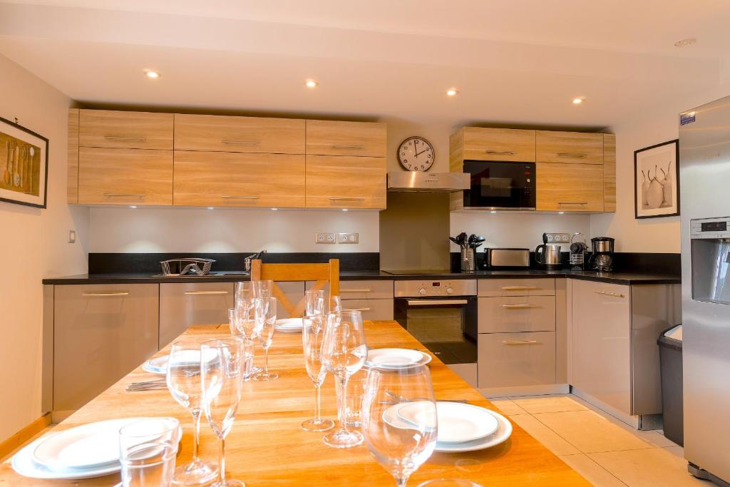 a kitchen with a wooden table with wine glasses on it at ORTA Chalet in Les Gets