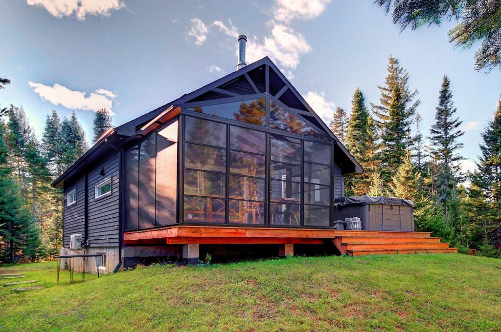 a black house on top of a grass field at Spa - Waterfront - Le Nordika in Valcartier Station