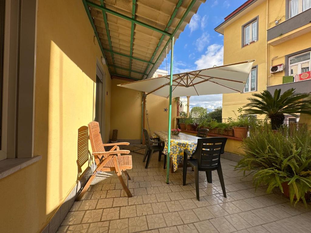 a patio with a table and chairs and an umbrella at Terra mia in Naples