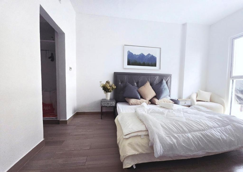 ein weißes Schlafzimmer mit einem großen Bett und einer Couch in der Unterkunft ARK Luxury Rooms walking Distance to Ferrari world, Yas Island in Yas Island