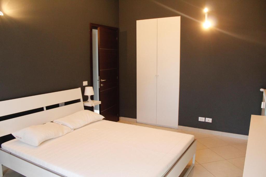 1 dormitorio con cama blanca y pared negra en San Donato Apartments, en Turín