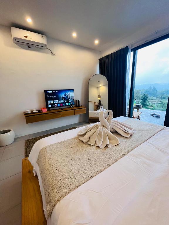a bedroom with a large bed with a large window at Pinggan harmoni in Baturaja